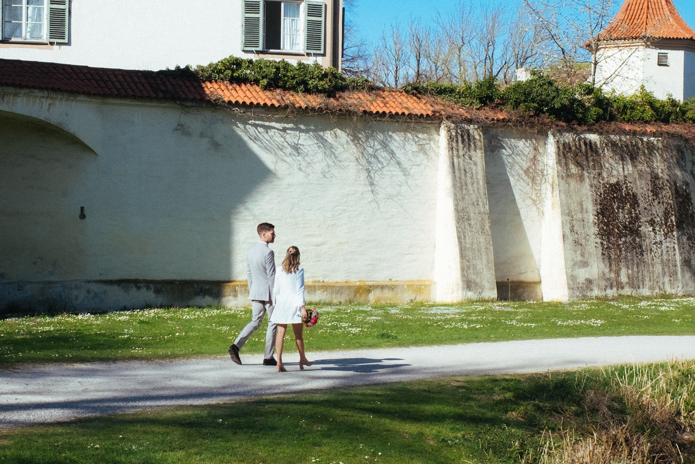 Das Brautpaar spaziert nach ihrer Trauung im Standesamt bei sonnigem Wetter