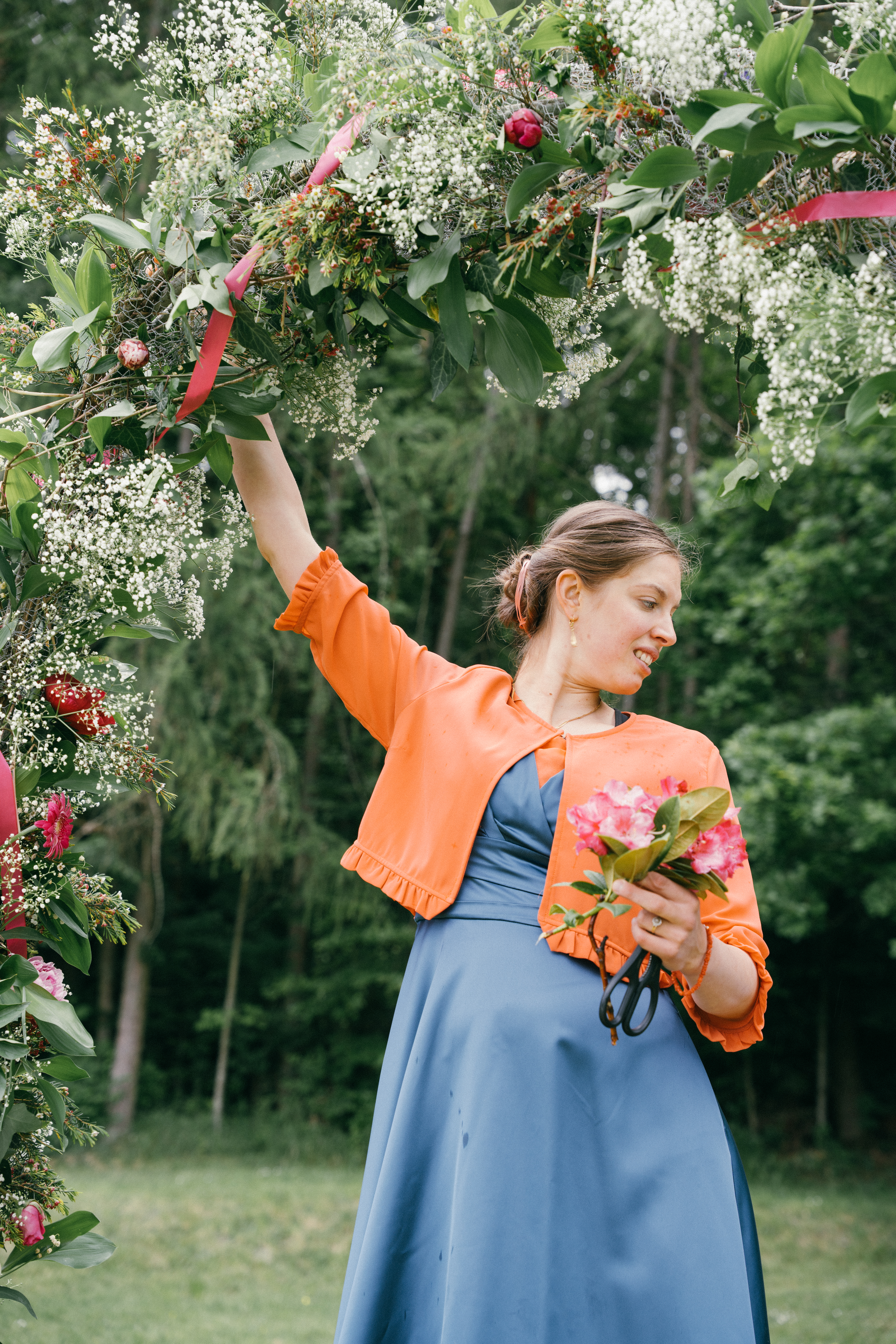 Frau bereitet Blumengesteck für Traubogen bei einer Hochzeit in Tübingen vor