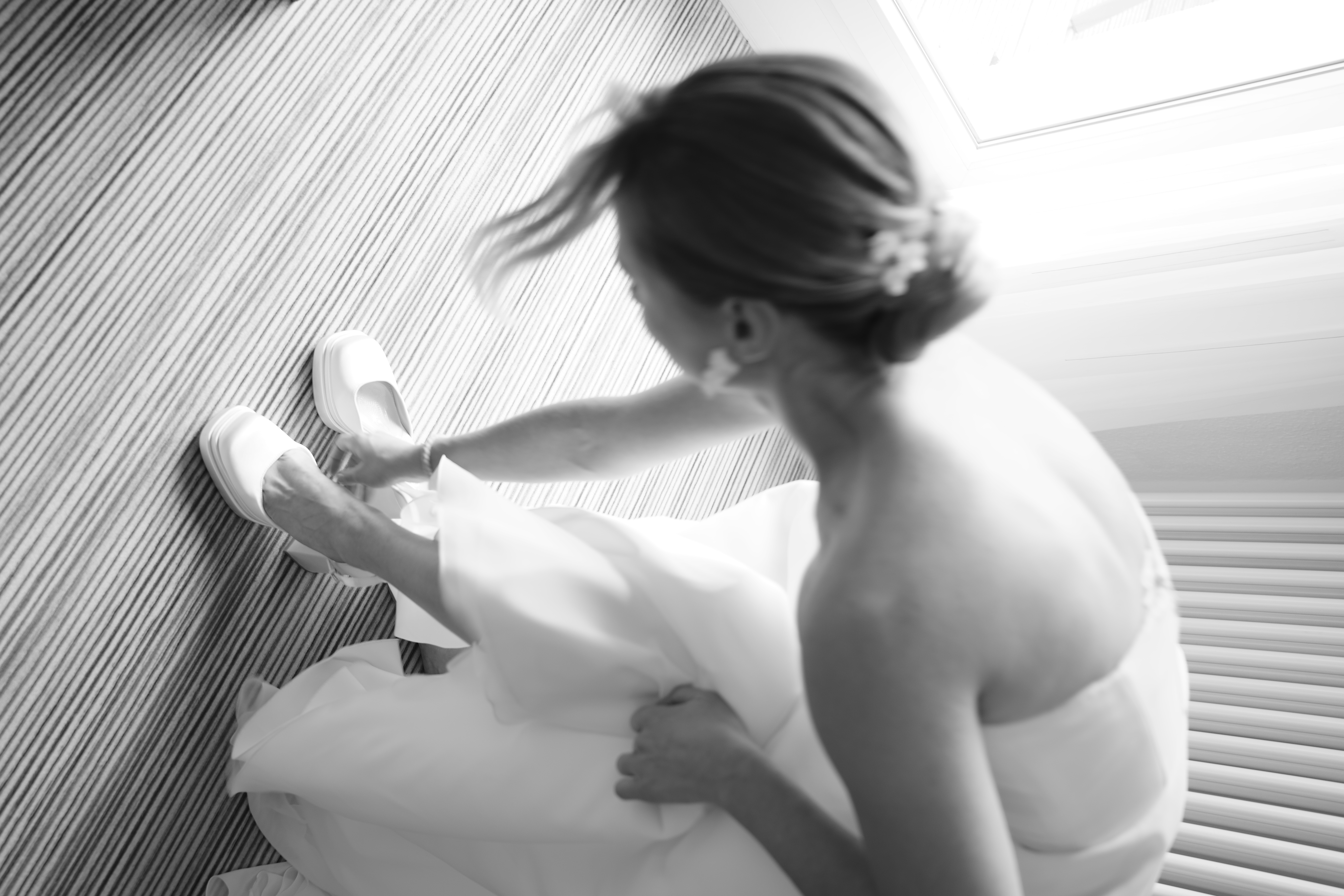 Braut beim getting ready zieht sich ihre Schuhe an in schwarz-weiß