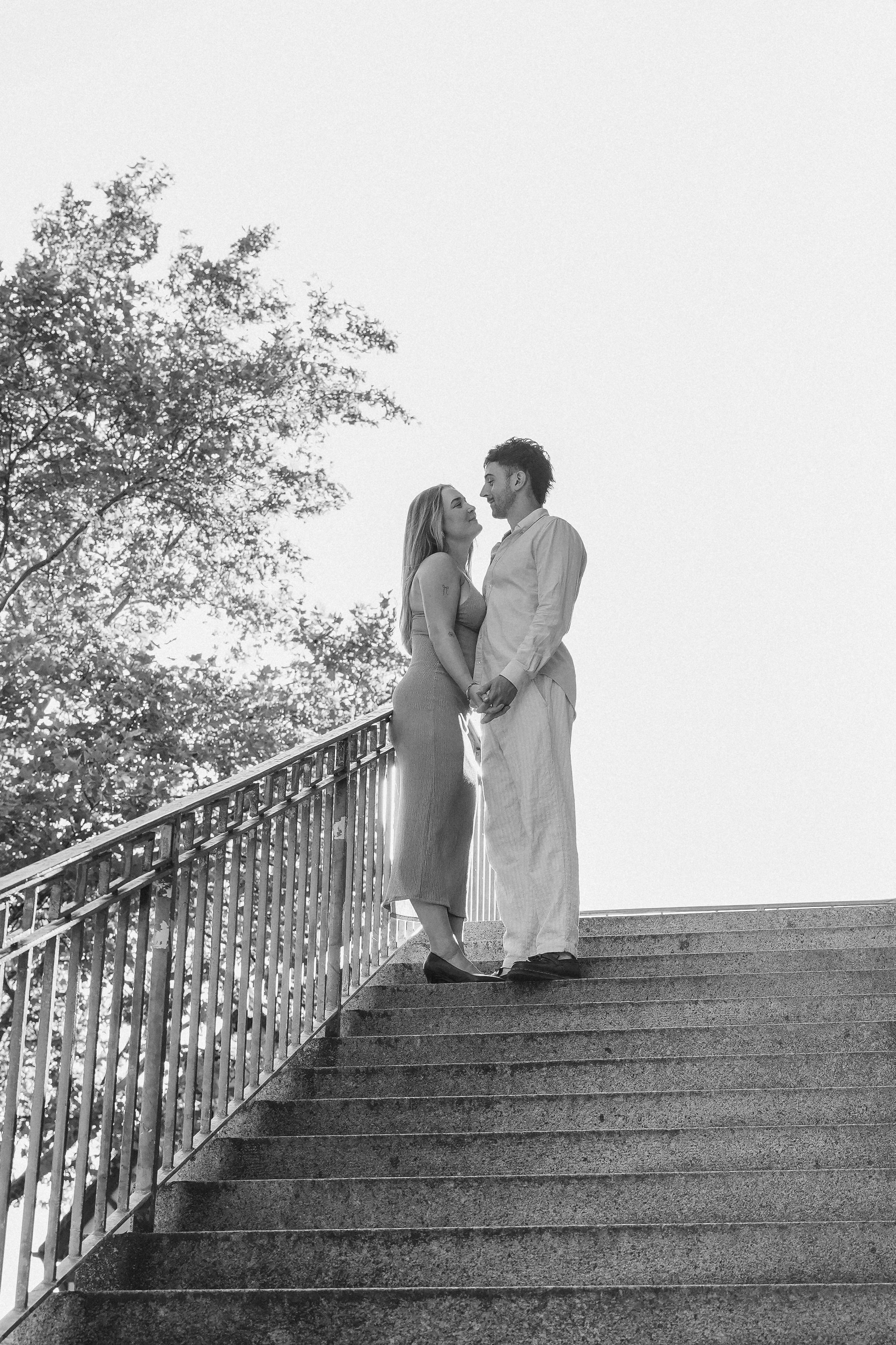 lachendes Paar steht vor Steinmauer in Tübingen beim Verlobungsshooting