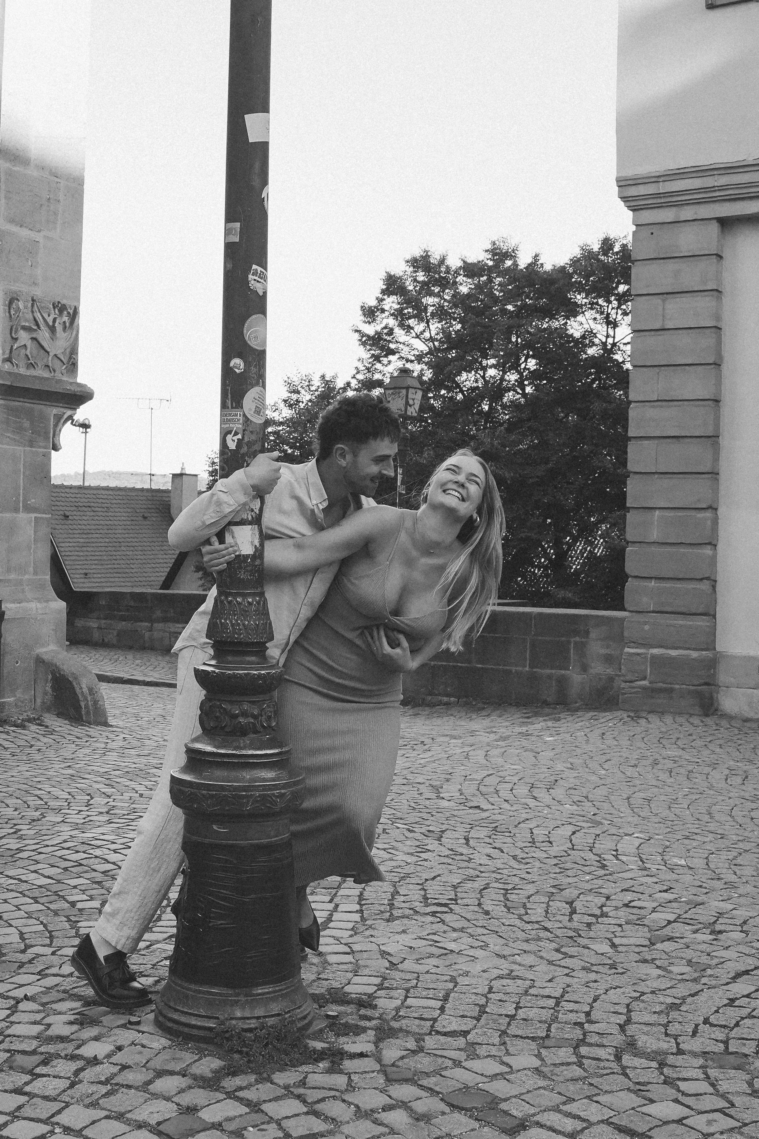 glückliches Paar an Laterne spielerisch umarmend in schwarz weiß in Tuebingen