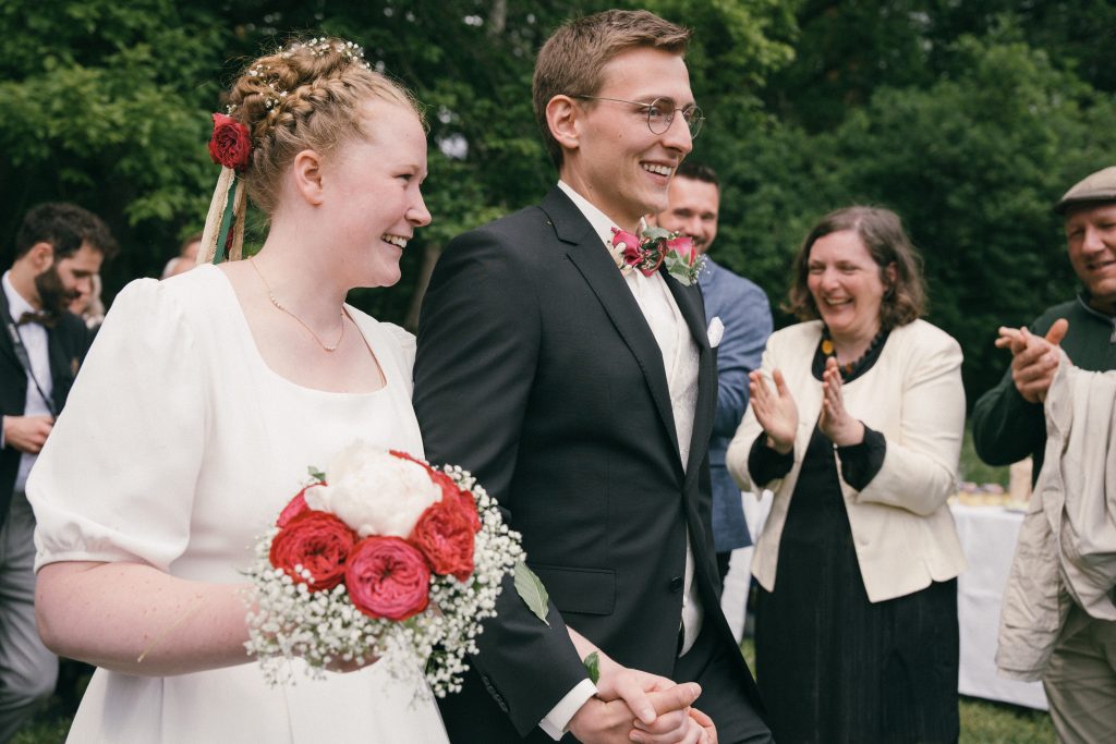 glückliches Brautpaar mit klatschenden Gästen nach freier Trauung in Tübingen