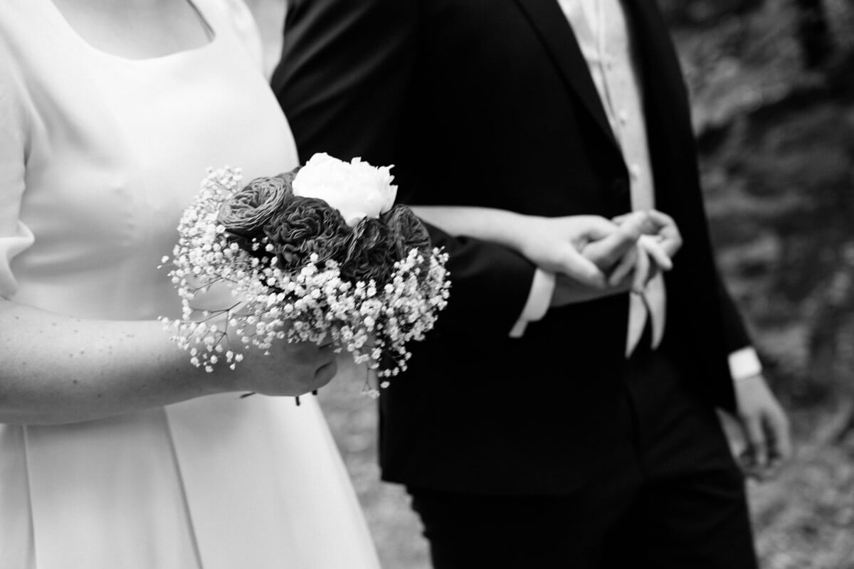 Brautpaar in schwarz-weiß läuft Hand in Hand zur Zeremonie in Tübingen