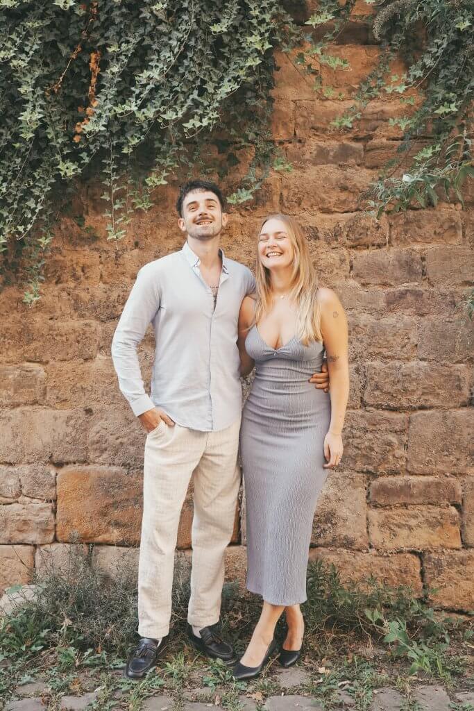 Paar steht lachend vor einer Mauer in Tuebingen