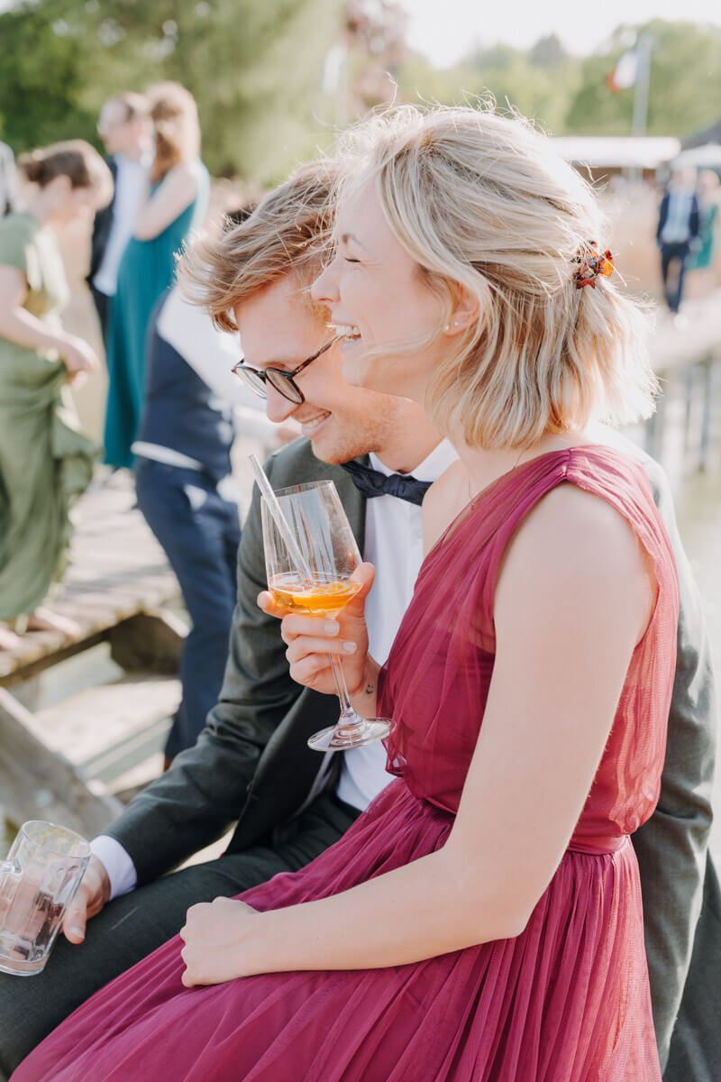 Ein Paar als Gast bei einer Hochzeit glücklich lachend