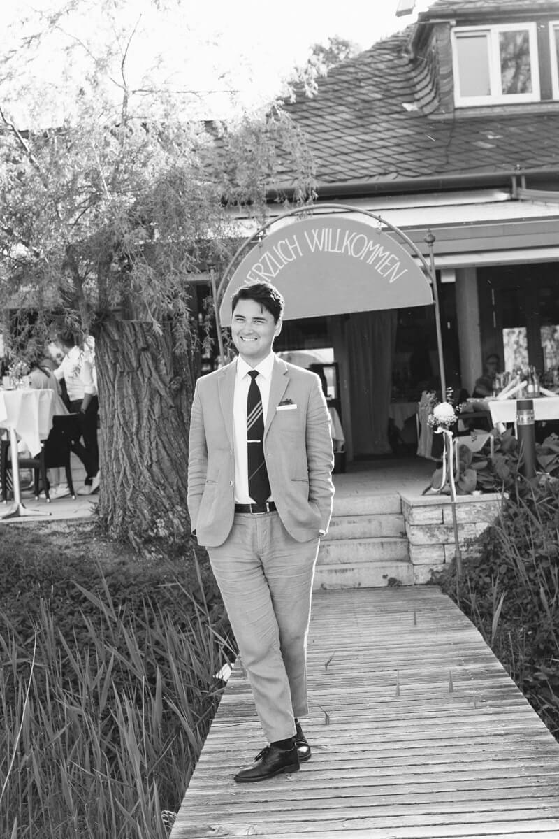 Der Bräutigam lachend bei der Hochzeit in schwarz weiß