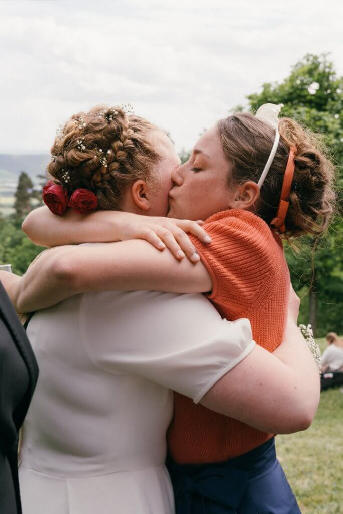 Braut wird von ihrer Schwester innig umarmt nach der Hochzeit in Tübingen