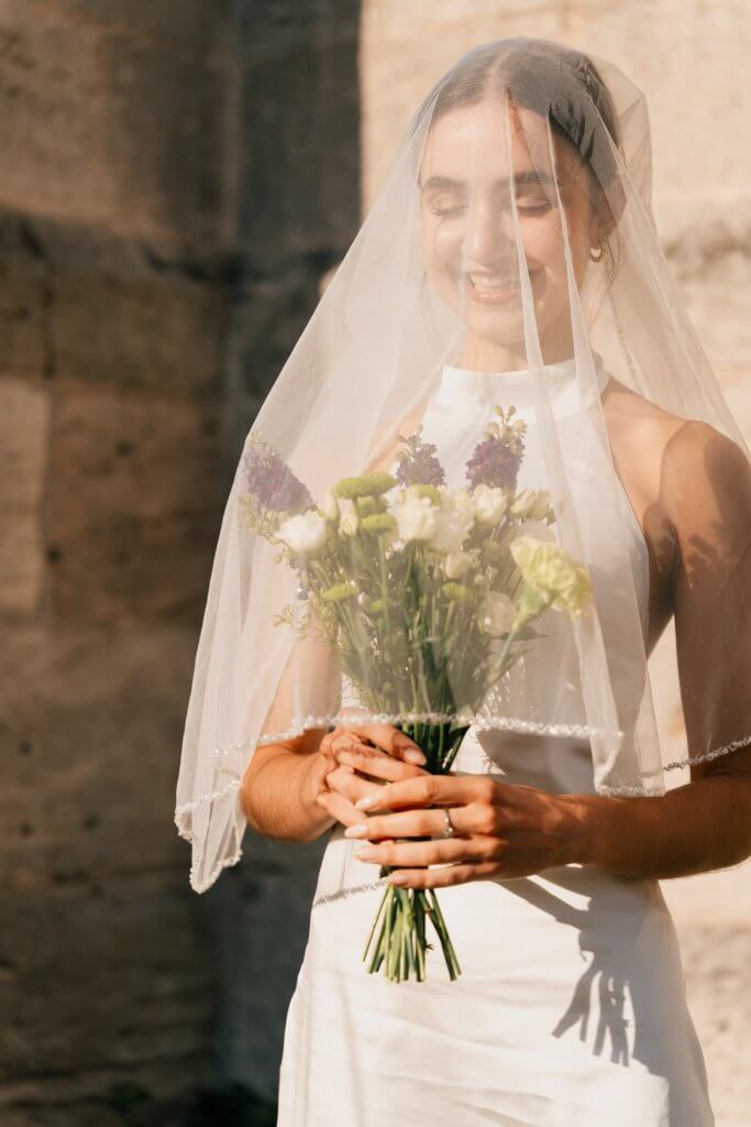 Braut mit Schleier und Brautstrauss nach ihrer Hochzeit in Tübingen 